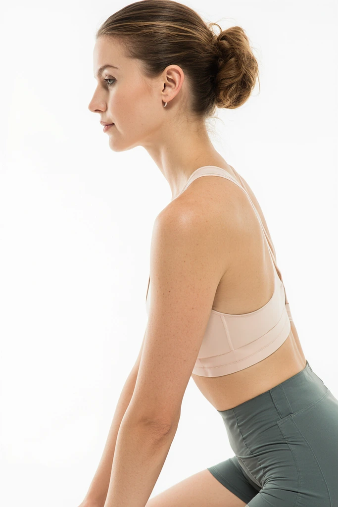 Young woman after lemon bottle fat dissolving wearing a sports bra and shorts.