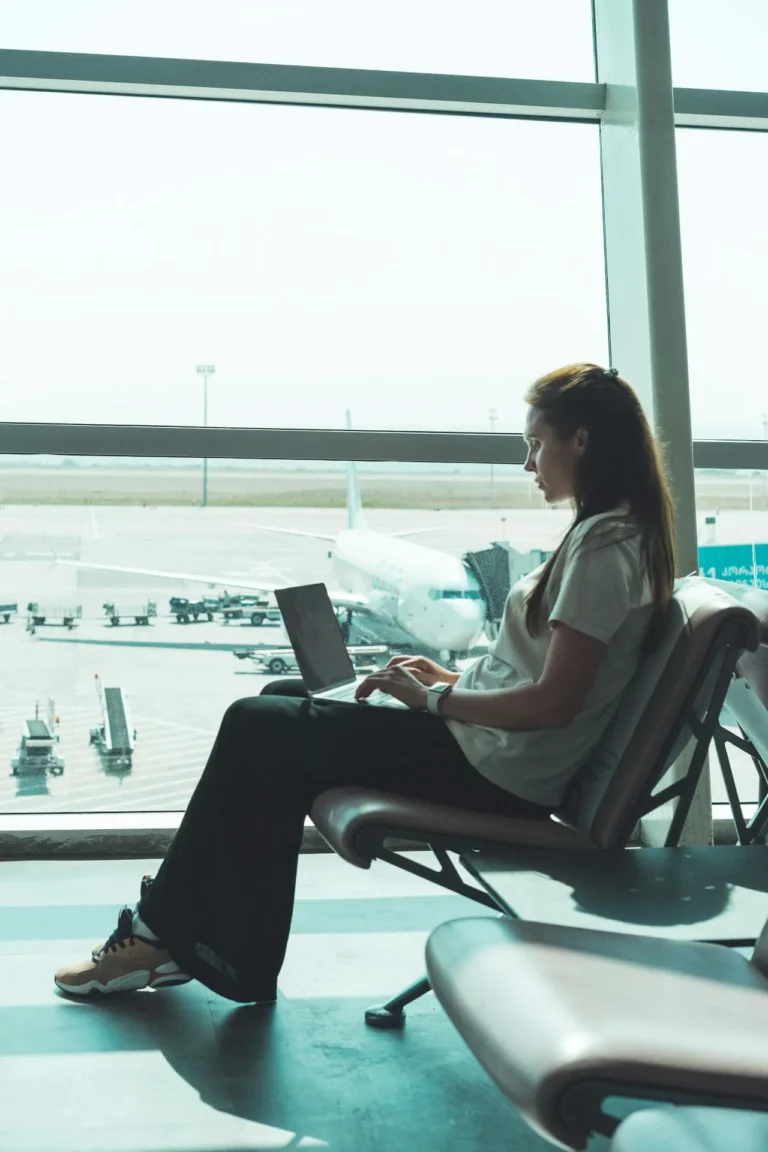 Woman with fresh dermal fillers waiting at the airport before the flight, illustrating post-treatment travel considerations.