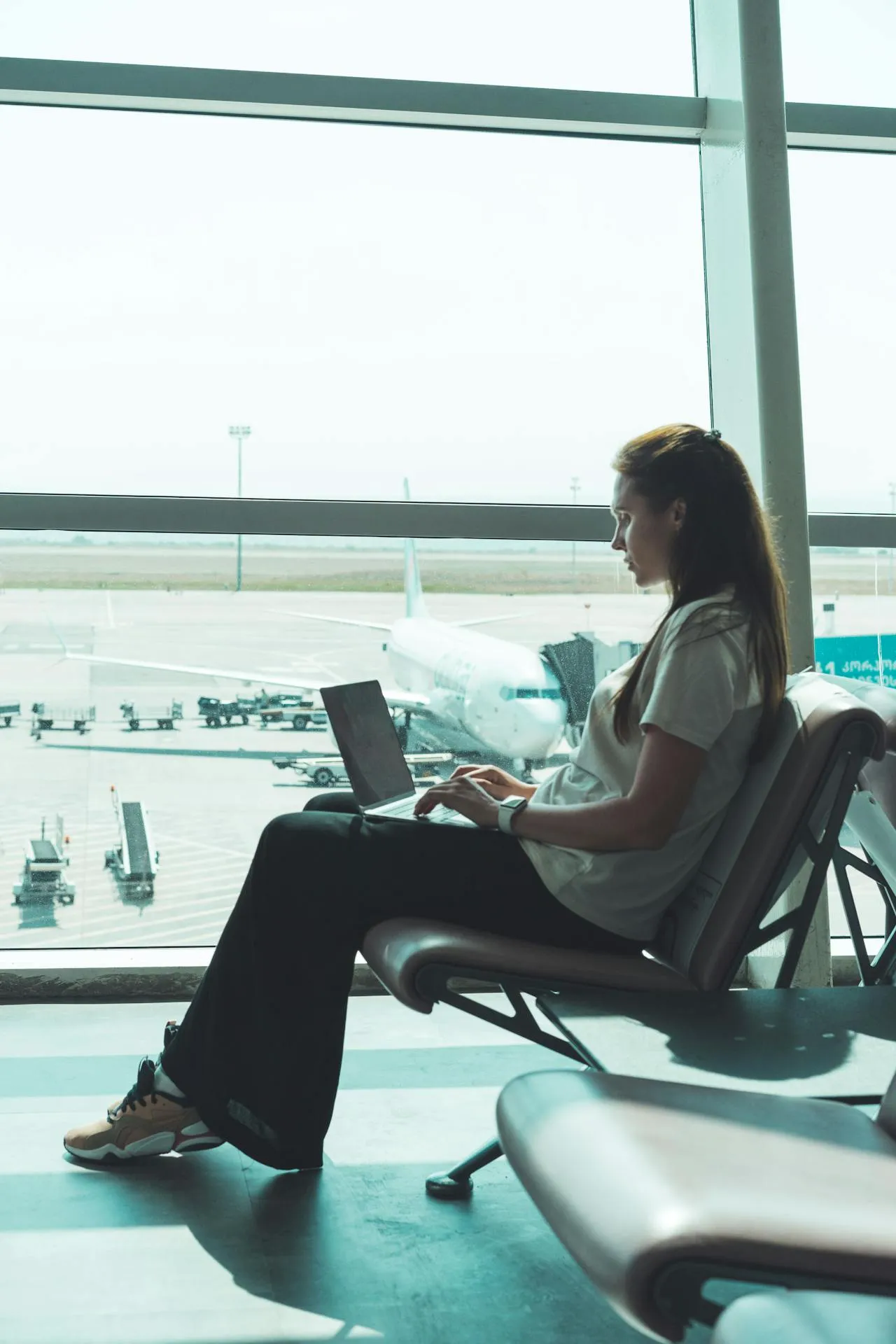 Woman with fresh dermal fillers waiting at the airport before the flight, illustrating post-treatment travel considerations.