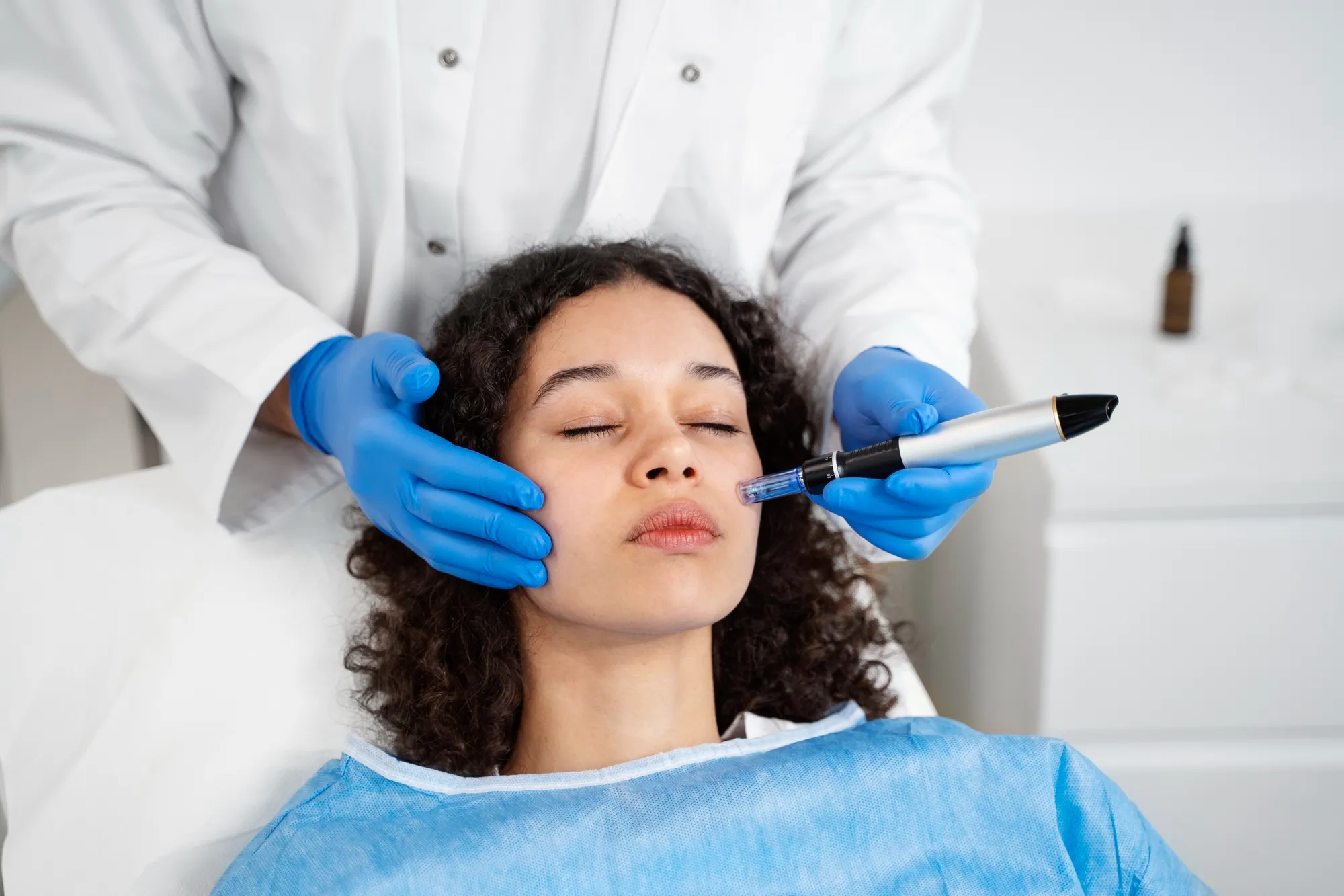 Woman receiving professional microneedling treatment during a skincare appointment to improve skin texture and stimulate collagen production.