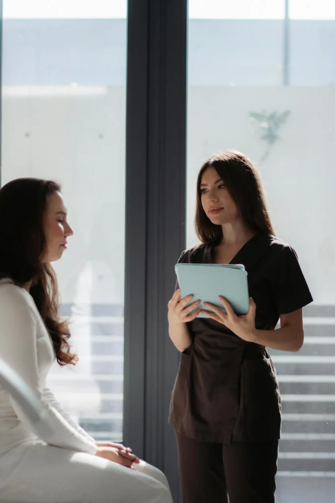 Medical professional consulting with patient about safety measures and preparation before nose filler treatment.