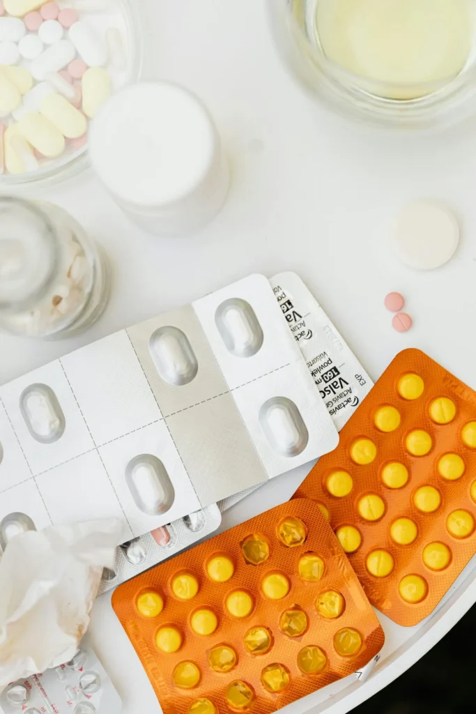 Assortment of prescription medications and supplements displayed before cosmetic lip filler procedure