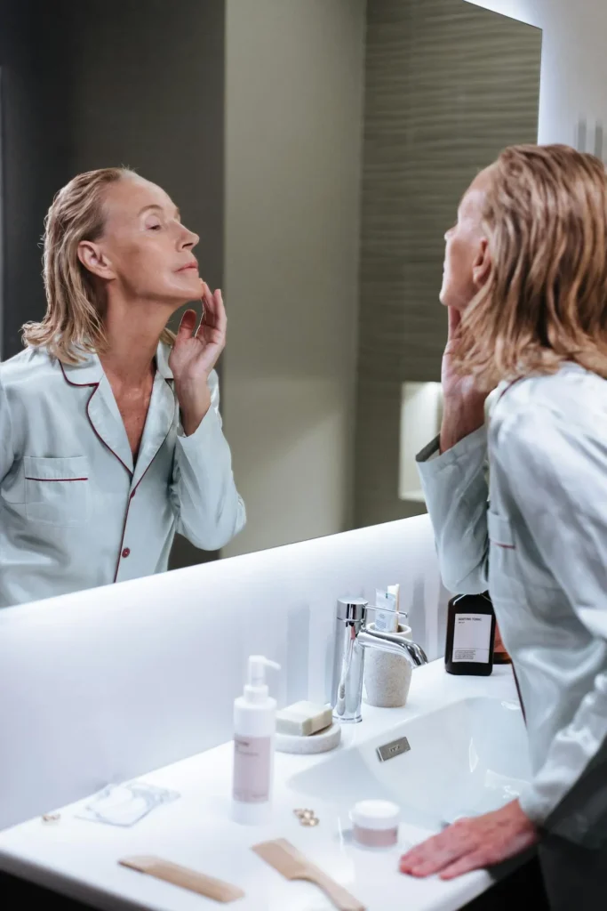 Woman examining smoother and healthier-looking skin after a series of microneedling treatments.