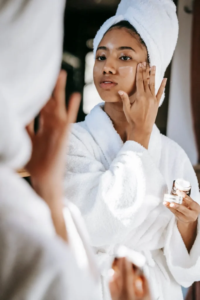 Woman applying skincare products and following pre-treatment instructions before a microneedling appointment