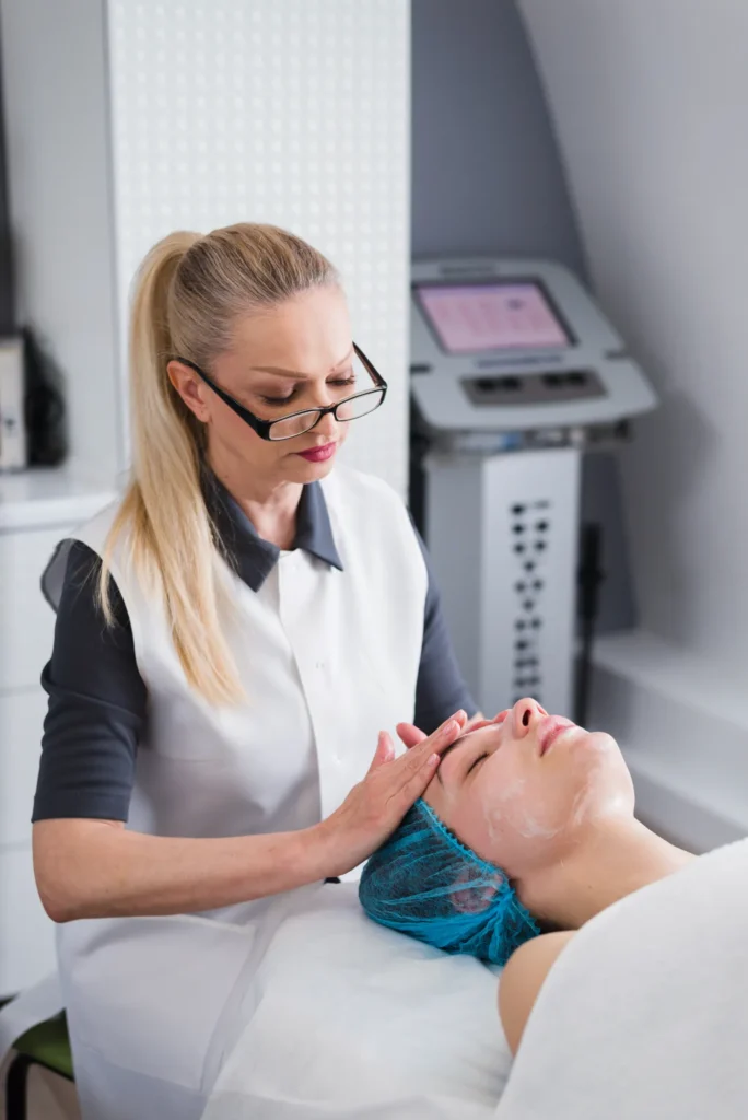 Woman receiving professional facial skin assessment before hydration-focused aesthetic treatment.