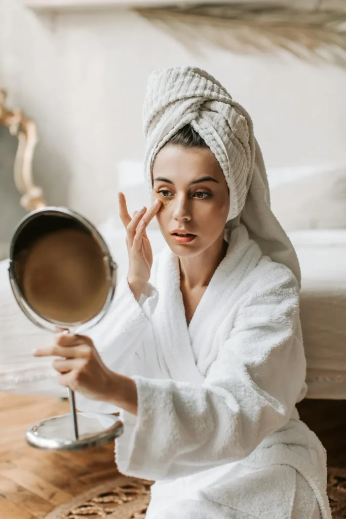 Woman examining her skin in a mirror while considering aesthetic treatments and learning about Botox and botulinum toxin products.