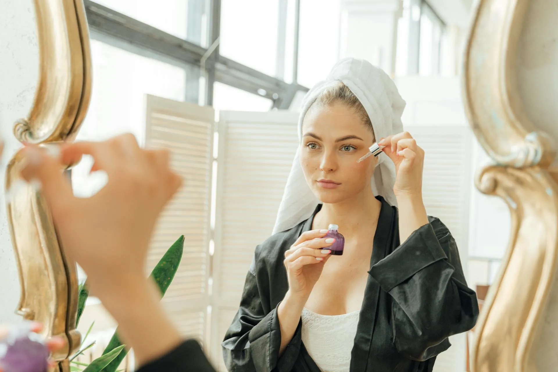 Young woman applying facial serum as part of a preventive beauty routine in her 20s