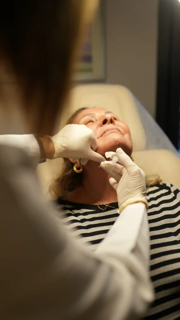 Medical professional performing chin filler injection with syringe