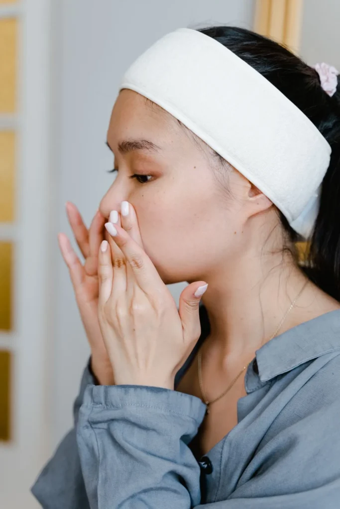 Woman applying lip balm as part of lip filler aftercare routine
